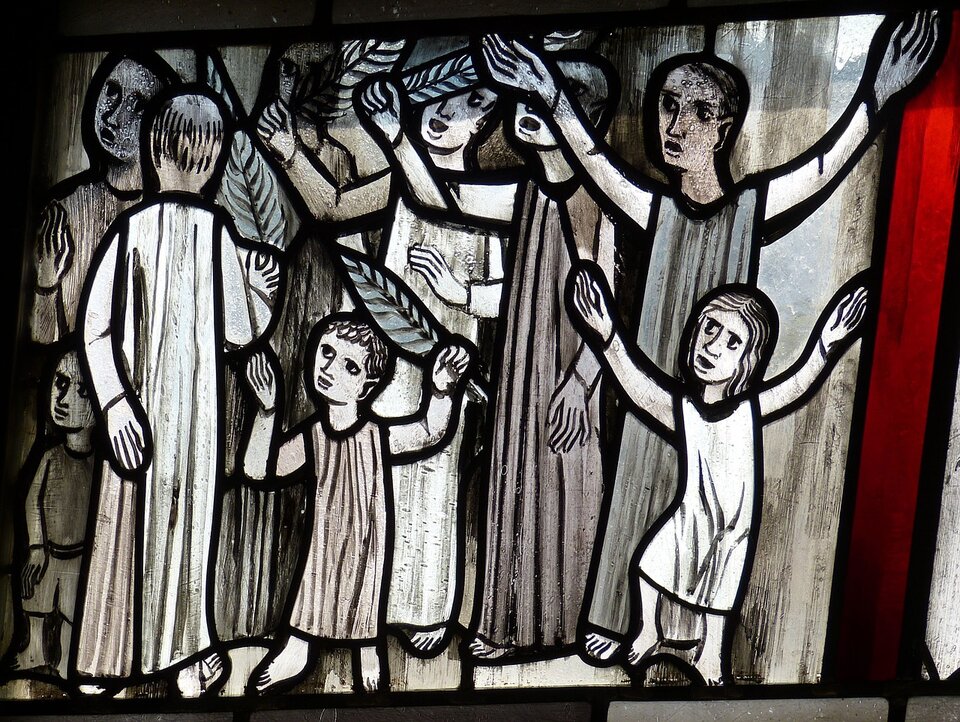 Witraż przedstawia tłum wiwatujących ludzi. Część z nich trzyma w dłoniach liście palmowe. Na pierwszym planie znajduje się dwoje dzieci, w tle stoją dorośli.