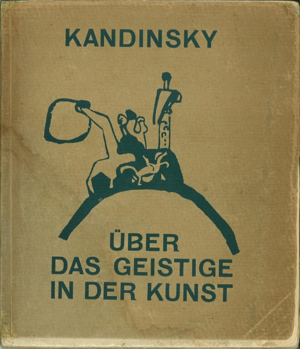 Okładka książki „Kandinsky: Über das Geistige in der Kunst” przedstawia na jasnobrązowym tle abstrakcyjną, czarną ilustrację złożoną z uproszczonych figur i linii. U góry widnieje duży napis „KANDINSKY”, a w dolnej części tytuł „ÜBER DAS GEISTIGE IN DER KUNST”. Tekst i ilustracja są utrzymane w ciemnym, niebieskozielonym kolorze. Na okładce widoczne są także ślady zużycia i przetarcia.