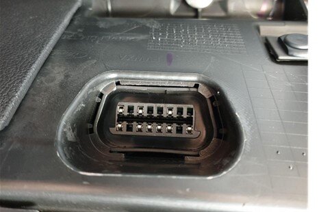 Na grafice ukazane gniazdo OBD, czyli złącze diagnostyczne w samochodach, pozwalające na połączenie zewnętrznych urządzeń diagnostycznych do komputera pojazdu.