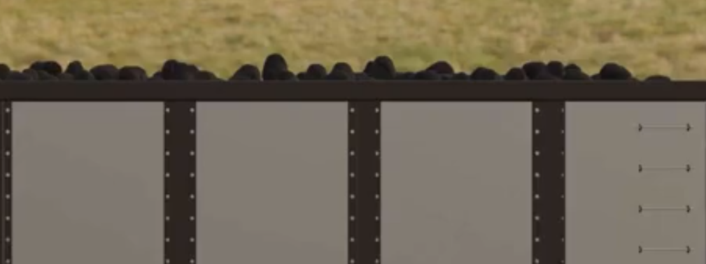 Ilustracja przedstawia górną część wagonu towarowego wypełnionego węglem.