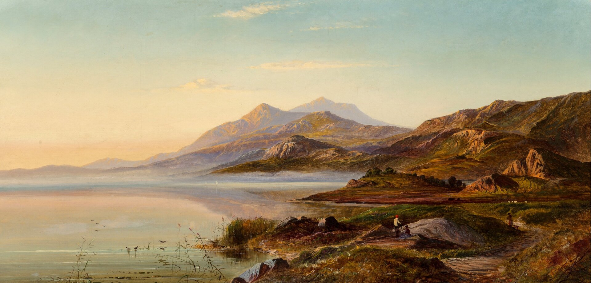 Ilustracja przedstawia jezioro oraz jego kamienisty brzeg. W tle szczyty gór.