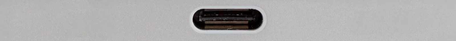 Fotografia przedstawiająca gniazdo USB typu C - na urządzeniu po środku znajduje się jeden wąski owalny otwór z odstającą w środku płaską płytką/stykiem.