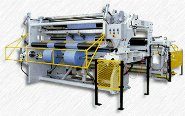 Na zdjęciu przedstawiono przewijarko‑krajarkę. Jest to duże urządzenie wyposażone w systemy wałów oraz ostrzy tnących.