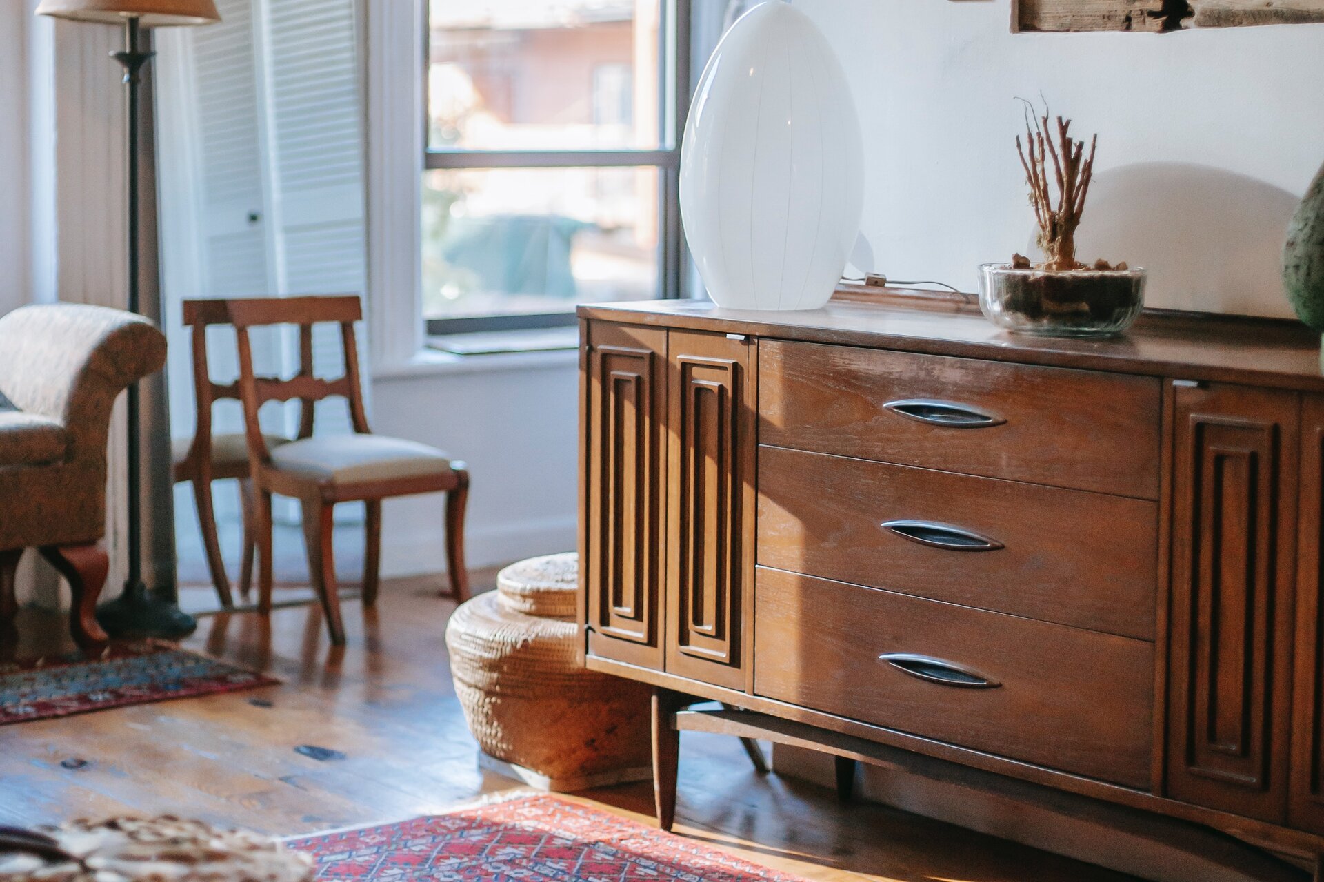 Zdjęcie przedstawia starą komodę z trzema szufladami.