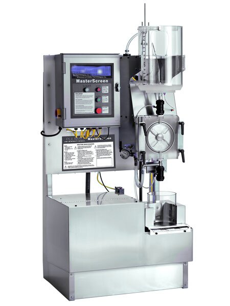 Na fotografii znajduje się urządzenie służące do oceny zawartości zanieczyszczeń w masie celulozowej. Na stalowej podstawie urządzenia znajdują się dwa zestawy elementów roboczych. Po prawej, szerszej części podstawy, umieszczona jest tabliczka z instrukcją obsługi, a nad nią kokpit sterujący z czterema opisanym i przyciskami i monitorem do wyświetlania wyników. Po lewej stronie znajduje się stalowa szuflada z dużą zlewką laboratoryjną, nad nią dozownik z pokrętłem hydraulicznym, a nad nim szklany zbiornik z podziałką.