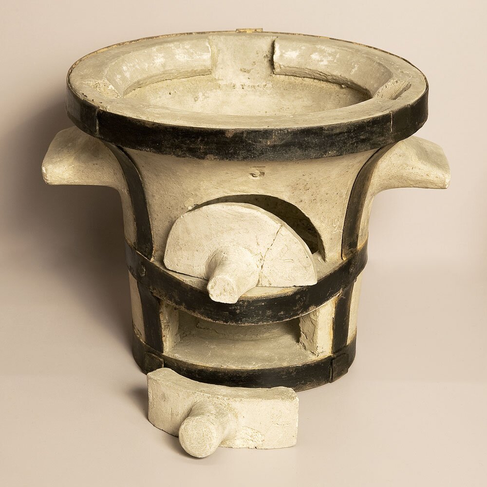 Zdjęcie przedstawiające piec z gliny szamotowej. Z przodu ma dwa otwory, które można przymknąć.