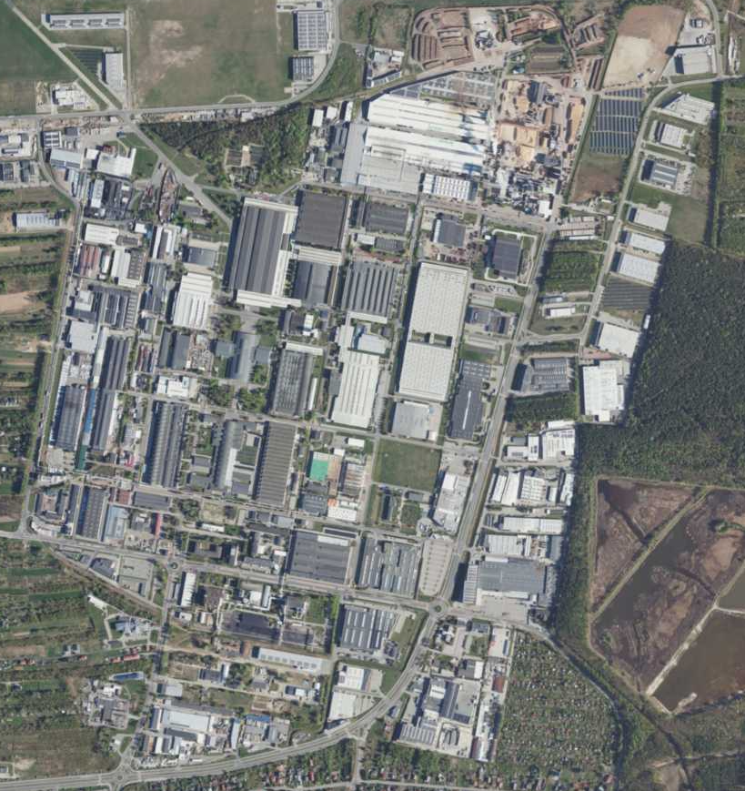 Ilustracja przedstawia zdjęcie z lotu ptaka na Specjalną Strefę Ekonomiczną Euro‑Park Mielec (SSE). Jest to duży kompleks wielu budynków. Nie znajduje się on w mieście, ponieważ wokół widnieją pola uprawne. 