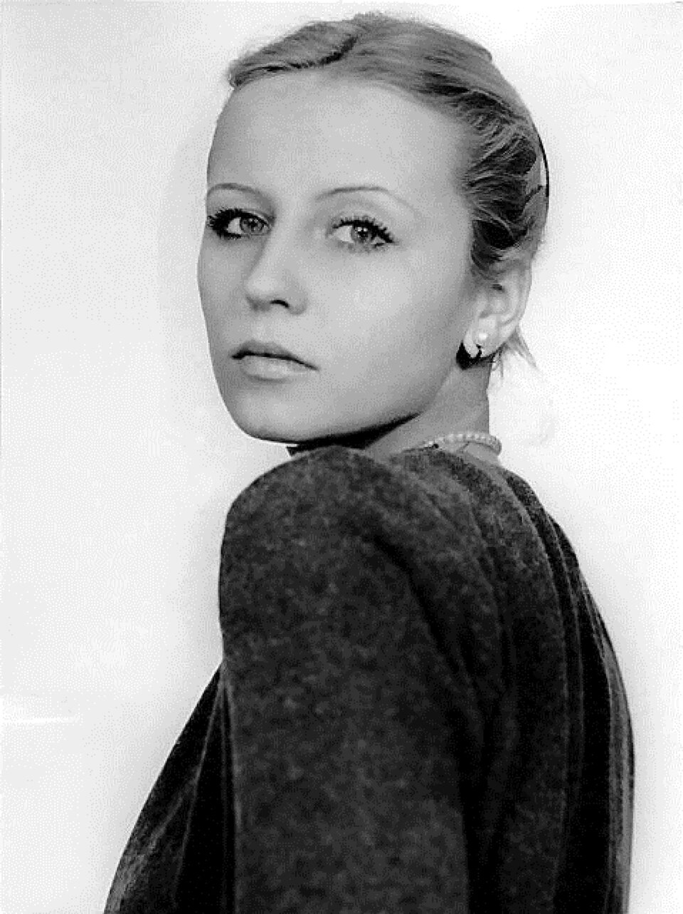 Ilustracja przedstawia czarno - białą fotografię młodej Krystyny Jandy, autorstwa Zofii Nasierowskiej pt. „Krystyna Janda”, na którym widoczna jest górna część sylwetki aktorki sceny teatralnej i filmowej. Aktorka pozuje bokiem, a jej głowa skierowana jest w lewą stronę, w kierunku obiektywu.