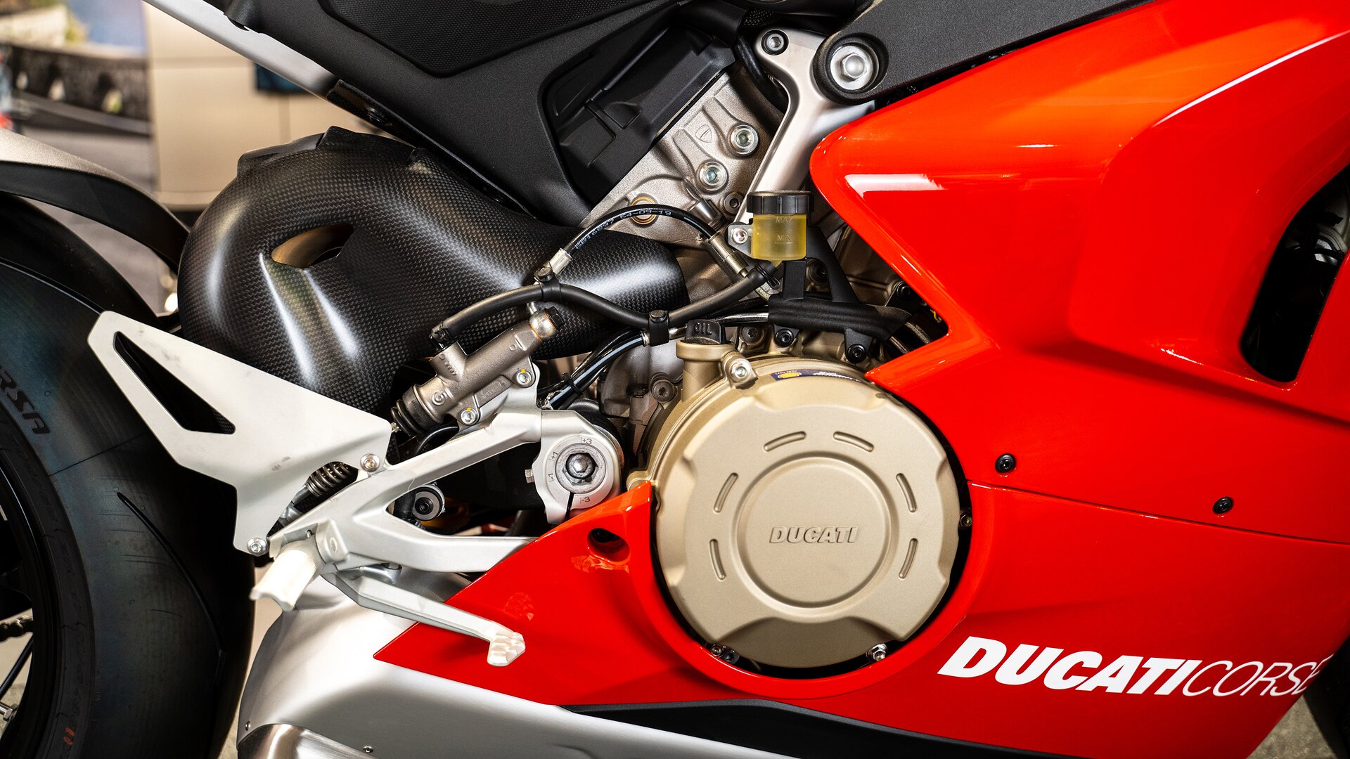 Zdjęcie przedstawia zbliżenie na elementy motocykla, między innymi na silnik, przewody.  