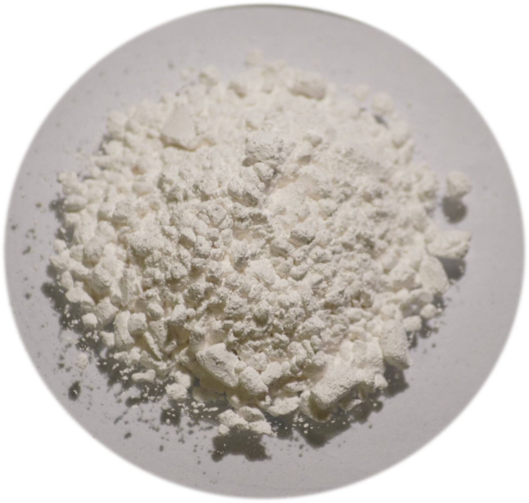 Ilustracja przedstawia częściowo sproszkowany, a częściowo zbity w grudki stosik białego proszku.