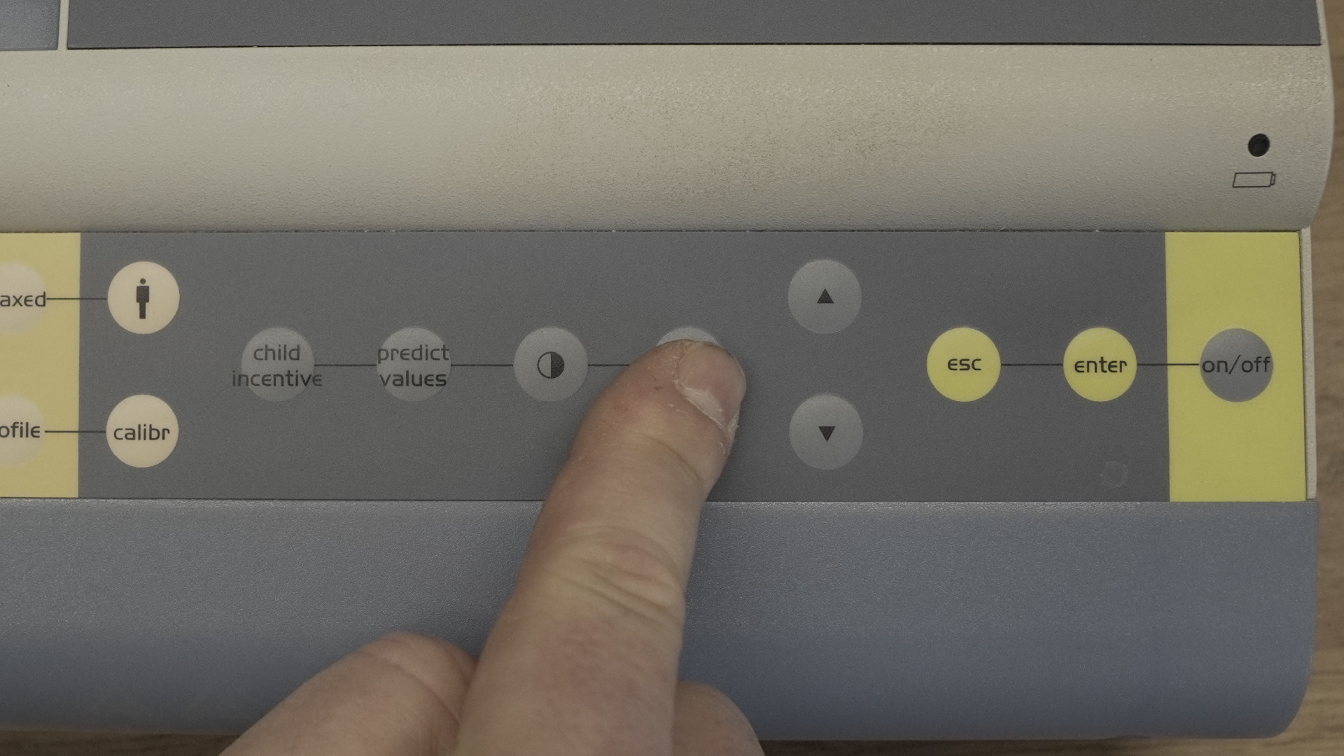 Na zdjęciu technik wybiera przycisk Menu na obudowie spirometru.