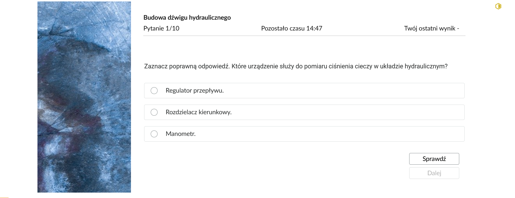 Grafika przedstawia przykładowe zadanie testowe. Ponad poleceniem widać numer pytania, czas, który pozostał na wypełnianie testu, oraz ostatni uzyskany wynik. Pod poleceniem znajdują się możliwe odpowiedzi. W prawym dolnym rogu panelu z zadaniem znajdują się dwa przyciski. Są to "Sprawdź" oraz "Dalej".