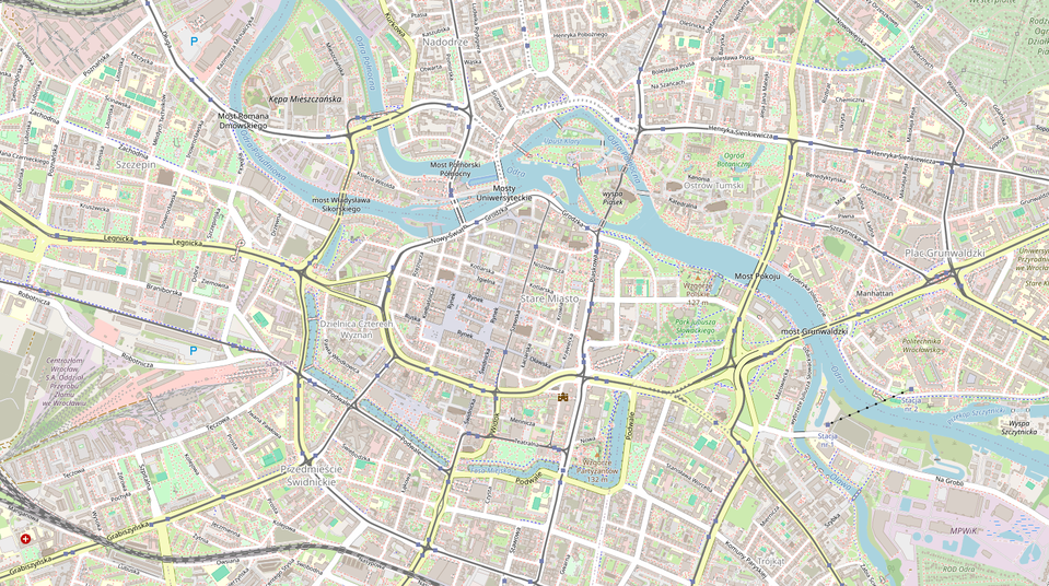Ilustracja przedstawia plan centrum Wrocławia. Tło jest szare, ulice są białe, ulice przelotowe żółte. Na mapie są nazwy placów, wysp na rzece i ulic. Z prawego dolnego rogu do lewego górnego rogu wije się oznaczona jasnoniebieskim kolorem Odra. Tereny, które są porośnięte roślinnością, zostały naniesione w kolorze zielonym.
