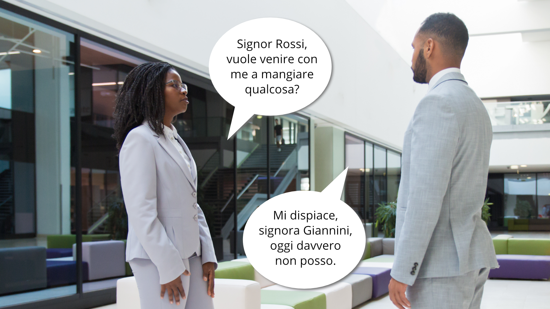 Zdjęcie przedstawia kobietę i mężczyznę w pracy. Stoją naprzeciwko siebie i rozmawiają. Obok narysowane są dymki, w których znajduje się tekst rozmowy. Kobieta zadaje pytanie, mężczyzna odpowiada: Singor Rossi, vuole venire con me a mangiare qualcosa?
Mi dispiace, signora Giannini, oggi davvero non posso.