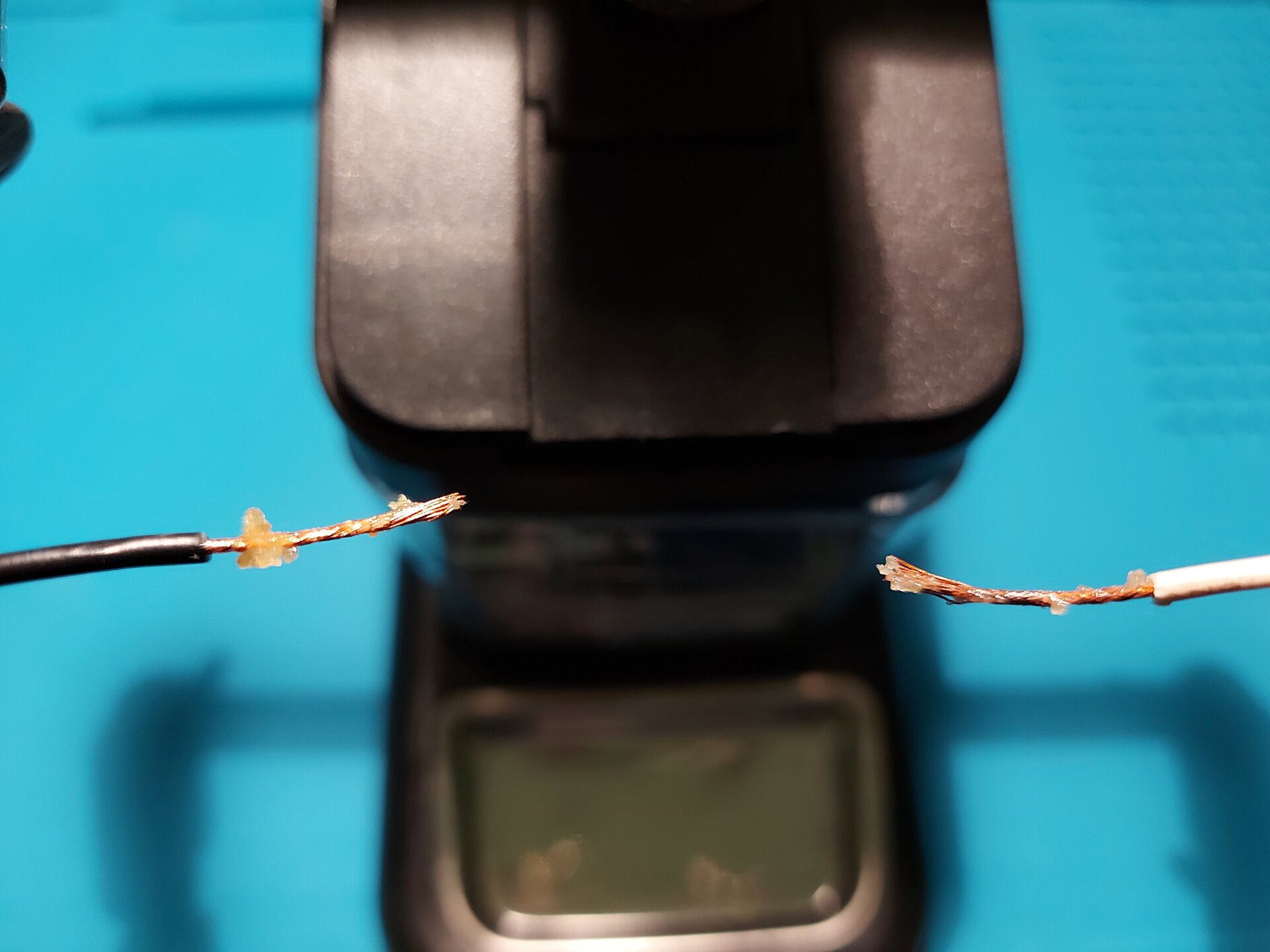 Zdjęcie przedstawia 2 przewody z usuniętą izolacją tym samym odsłaniając miedziane wnętrze, na które nałożono pastę.