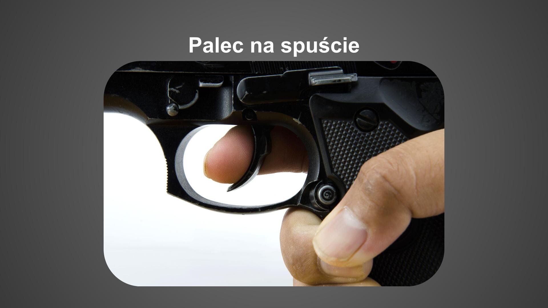 Szara plansza. U góry biały napis: „Palec na spuście”. Poniżej zdjęcie przedstawiające dłoń trzymającą pistolet. Palec ułożony jest na spuście.