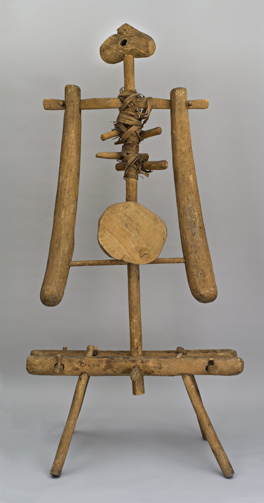 Zdjęcie przedstawia pomnik autorstwa Jerzego Beresia, pod tytułem: „Zwid II”. Na fotografii przedstawiono drewnianą kompozycję. Po bliższym przyjrzeniu nabiera cech człowieka. Rzeźba składa się z drewnianych elementów przypominających nogi, ręce, tułów, szyję oraz głowę. Kompozycja ukazana jest na szarym tle.