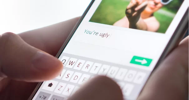 Ekran smartfona, na którym ktoś pisze wiadomość o treści: You’are ugly (Jesteś brzydki/a)