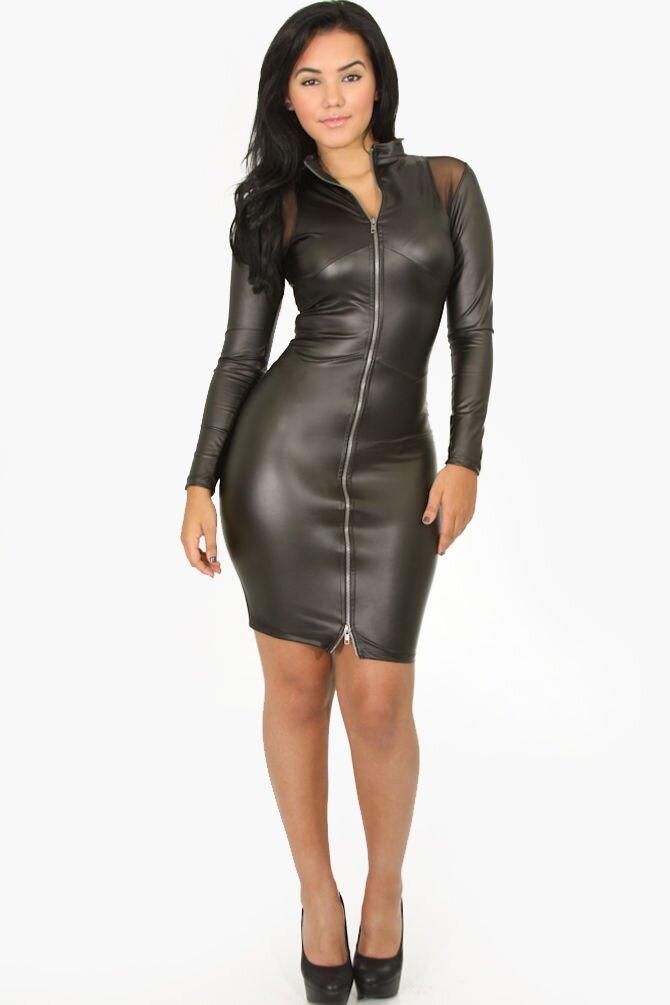 Zdjęcie przedstawia modelkę prezentującą czarną sukienkę z krótkimi rękawami, sięgającą przed kolana. Materiał sukienki przypomina skórę.Nagranie tożsame z treścią.