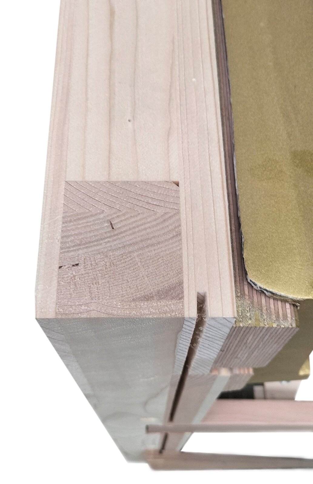 Zdjęcie przedstawia szkielet, strojnicę i fragment ramy żeliwnej pianina. Szkielet i strojnica wykonane z jasnobeżowego drewna sosnowego i jasnobrązowego drewna bukowego. Fragment ramy żeliwnej po prawej stronie ma kolor starego złota.