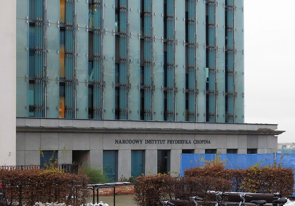 Fotografia przedstawia fragment wielokondygnacyjnego, nowoczesnego budynku. Znajduje się na nim napis Narodowy Instytut Fryderyka Chopina.