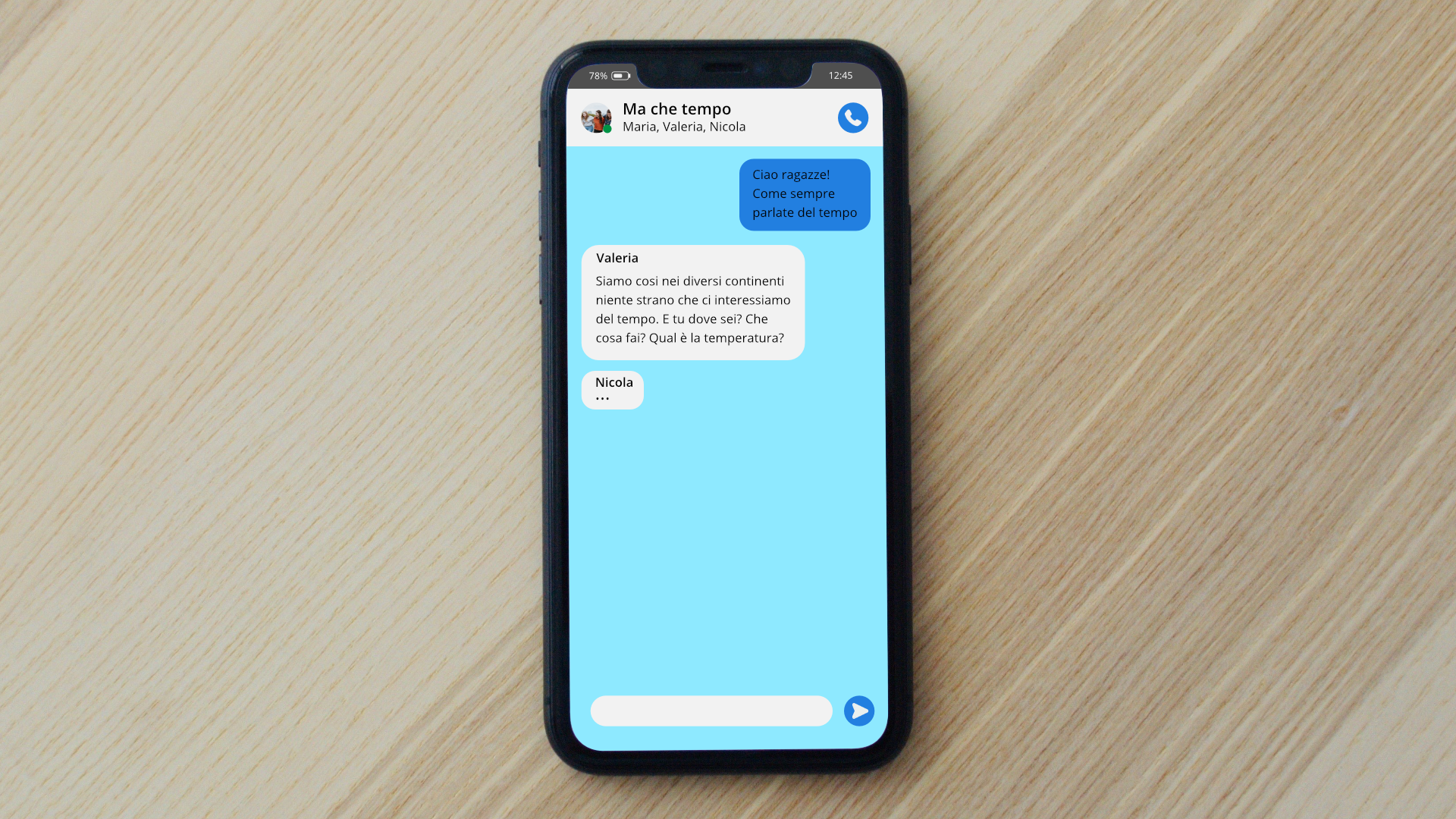Zdjęcie przedstawia telefon komórkowy, na którym wyświetlona jest rozmowa na czacie. Tekst na ekranie telefonu: Me che tempo. Maria, Valeria, Nicola. W pierwszym dymku znajduje się tekst: Ciao ragazze! Come sempre parlate del tempo. W drugim dymku znajduje się tekst: Valeria: Siamo cosi nei diversi continenti niente strano che ci interessiamo del tempo. E tu dove sei? Che cosa fai? Qual e la temperatura? W trzecim dymku znajduje się imię Nicola oraz trzy kropki.
