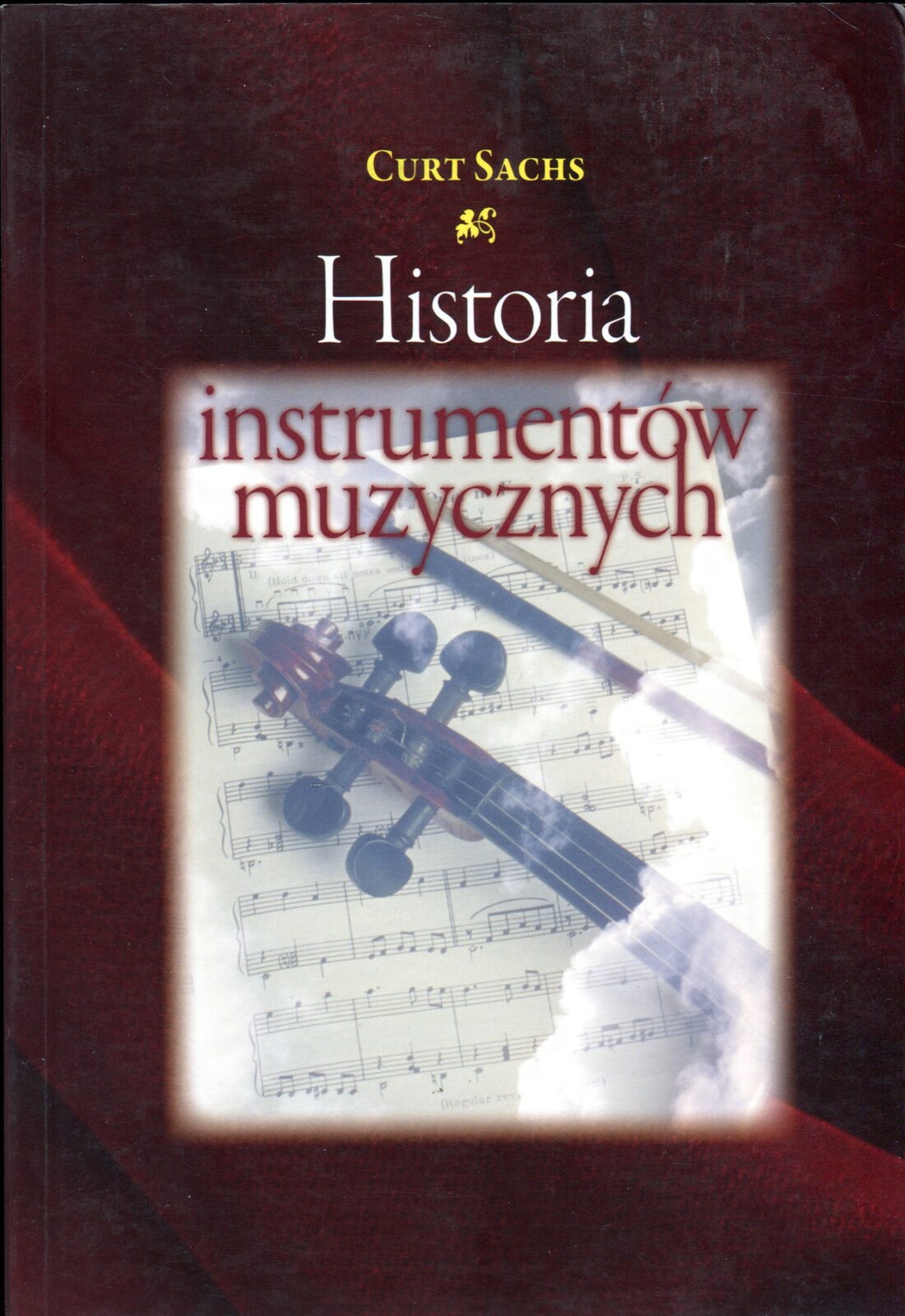 Fotografia przedstawia okładkę książki autorstwa Curta Sachsa pod tytułem „Historia instrumentów muzycznych” w przekładzie Stanisława Olędzkiego. Okładka utrzymana jest w odcieniach koloru czerwonego, wewnątrz odgrodzona jasnym tłem na której umieszczono ilustrację partytury i skrzypiec. Imię i nazwisko autora książki oznaczono kolorem złotym, zaś tytuł kolorami białymi - napis: HISTORIA oraz czerwonymi - napis: instrumentów muzycznych.