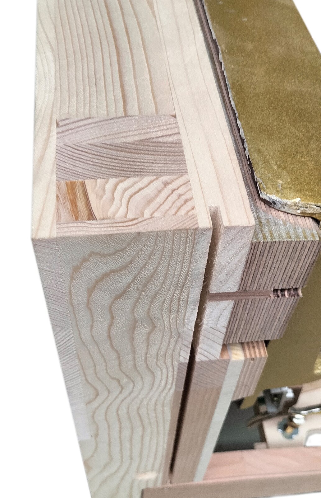 Zdjęcie przedstawia szkielet, strojnicę i fragment ramy żeliwnej pianina. Szkielet i strojnica wykonane z jasnobeżowego drewna sosnowego i jasnobrązowego drewna bukowego. Fragment ramy żeliwnej po prawej stronie ma kolor starego złota.