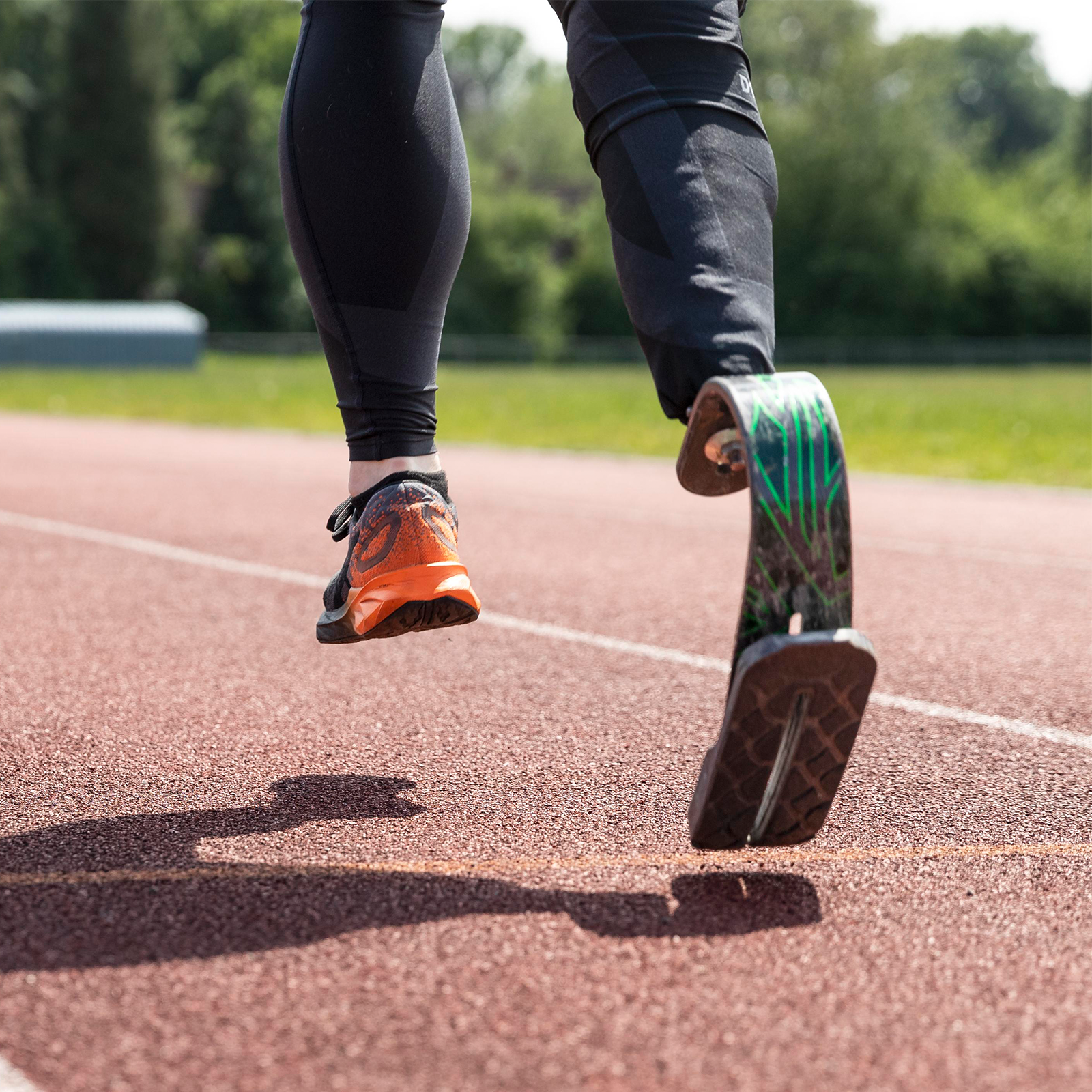 Zdjęcie przedstawia biegacza, którego prawa noga jest zastąpiona protezą. 