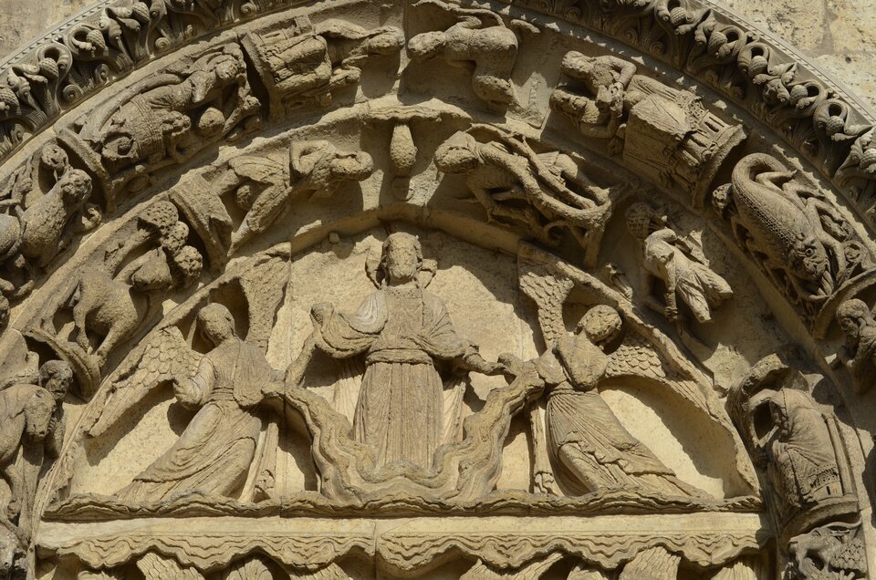 Ilustracja przedstawia lewy portal katedry w Chartres, które ukazuje Wniebowstąpienie Chrystusa. Pozy aniołów, znajdujących się po bokach, dopasowane są do kształtu tympanonu. Tympanon otoczony jest od góry łukami archiwolt z dekoracją w postaci znaków zodiaku.