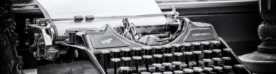  Zdjęcie przedstawia zabytkową, mechaniczną maszynę do pisania. Widoczna jest gęsta siatka okrągłych klawiszy na metalowych ramionach. Na obudowie, tuż pod wałkiem, widnieje wyraźny napis „CONTINENTAL”.