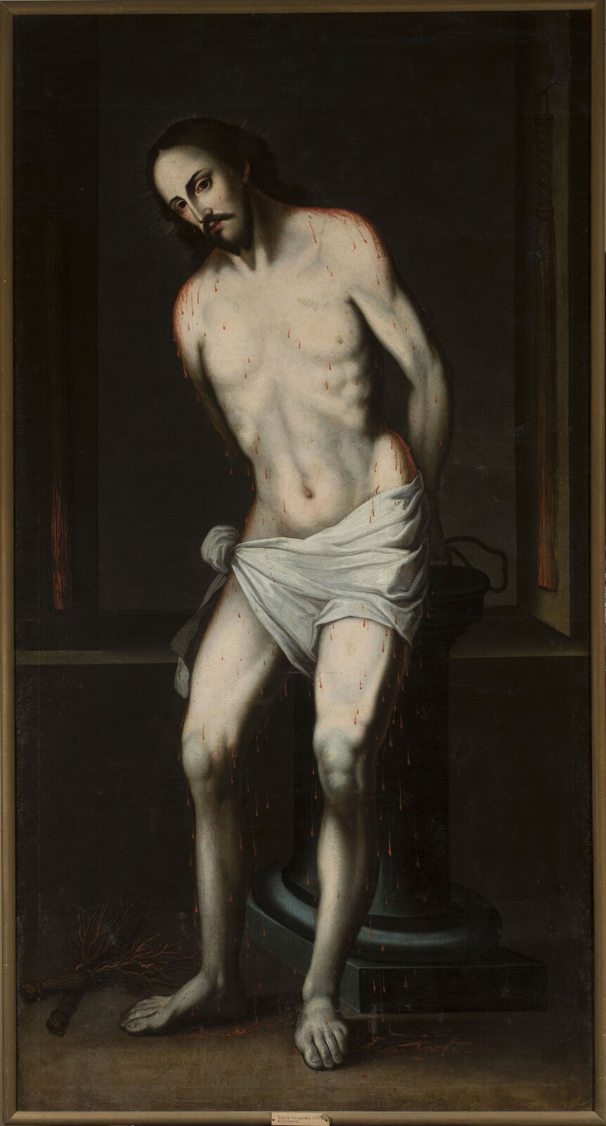 Obraz przedstawia młodego mężczyznę stojącego przy kolumnie. Jest półnagi, na biodrach ma tylko przewiązaną białą szatę. Na ciele widać liczne cienkie strużki krwi. Jego ręce przywiązano z tyłu do kolumny. Mężczyzna jest lekko pochylony w prawą stronę. Ma ciemne, długie włosy z przedziałkiem, zaczesane do tyłu, wąsy i niewielką bródkę. Tło jest ciemne.