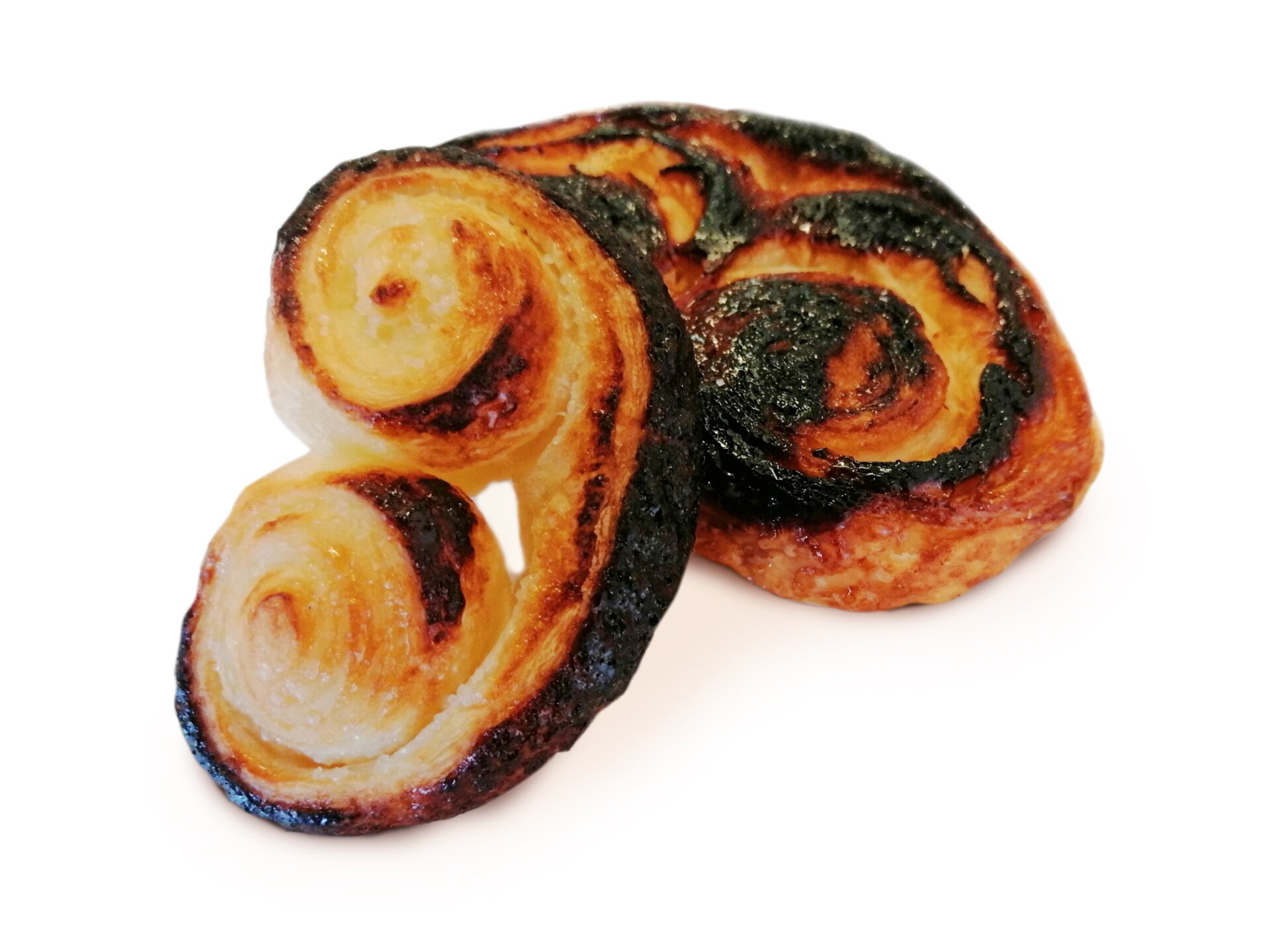 Spalone ciastka, których boki zwinięte są w rulony. Brzegi mają kolor czarny.