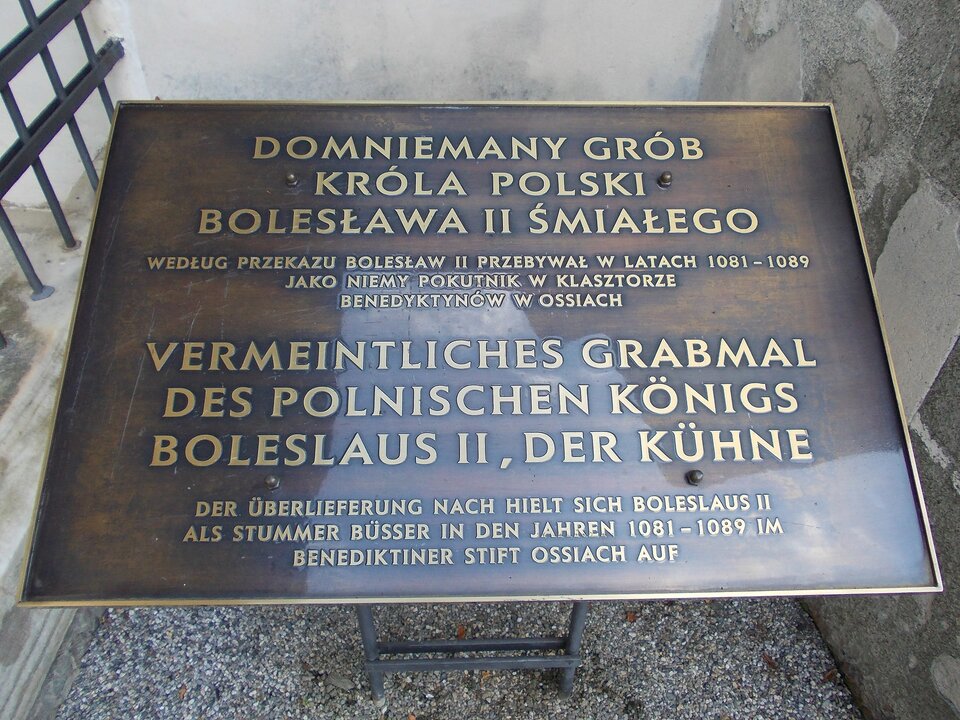 Zdjęcie przedstawia tablicę na grobie Bolesława drugiego Szczodrego. Znajduje się na niej napis w języku polskim i niemieckim. Domniemany grób króla polski Bolesława drugiego Śmiałego. Według przekazu Bolesław drugi przebywał w latach od 1081 do 1089 jako niemy pokutnik w klasztorze benedyktynów w ossiach.