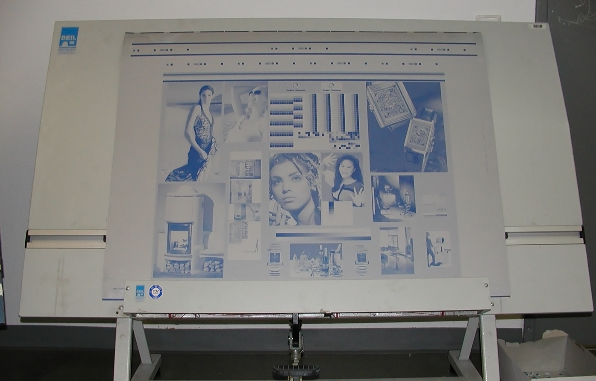 Zdjęcie przedstawia przykładową naświetloną i wywołaną płyta presensybilizowaną pozytywową. Forma drukowa offsetowa jest wykonana z płyty aluminiowej o ziarnowanej, anodowanej powierzchni z naniesioną warstwą kopiową. Na powierzchni formy widoczne różnego rodzaju grafiki (postaci, twarze) w kolorze ciemnoniebieskim na białym tle.