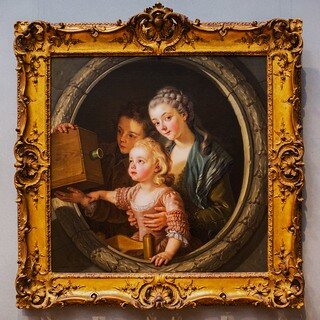 Zdjęcie przedstawia XVIII wieczny portret kobiety z małym dzieckiem na kolanach i chłopcem, wychylającym się z tyłu i trzymającym w rękach camerę obscura. Obraz ma bogate, złocone ramy.