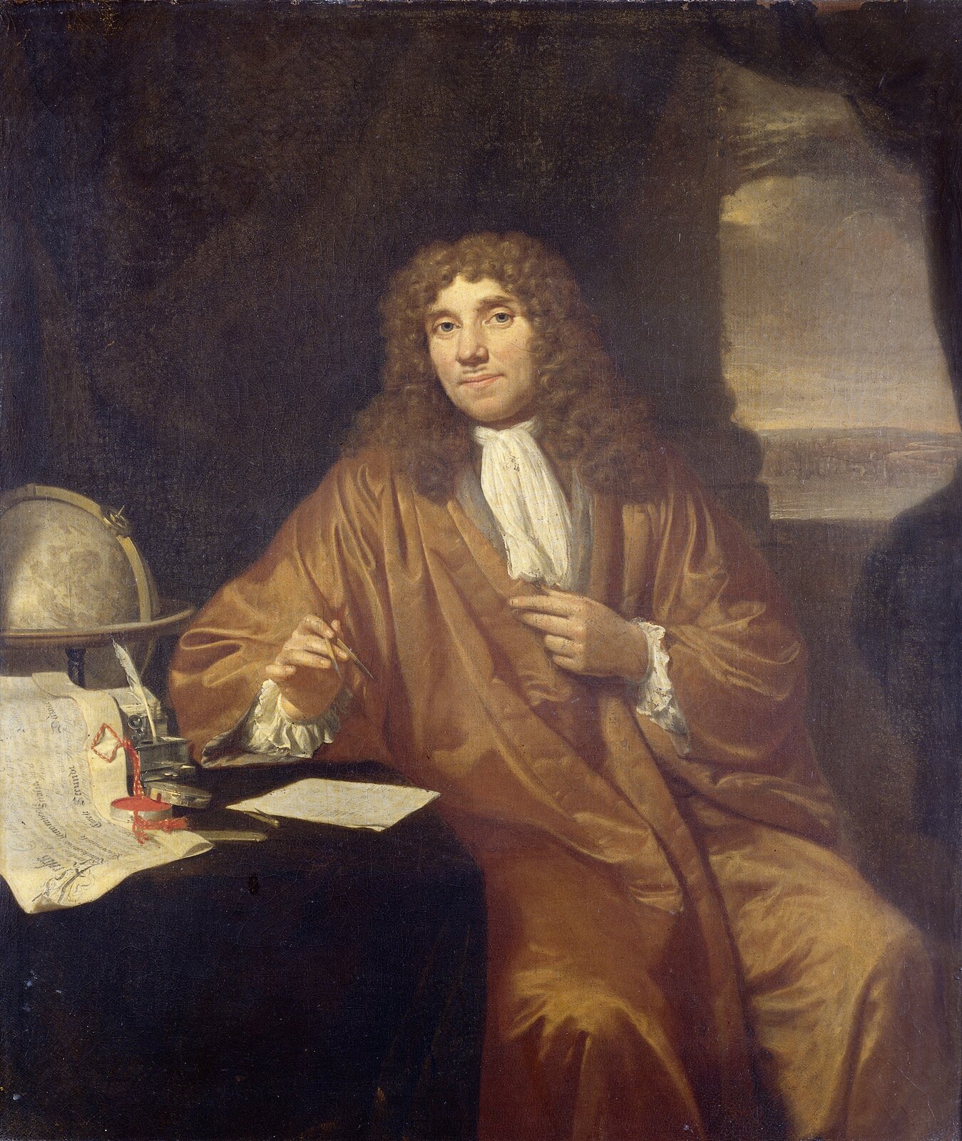 Portret siedemnastowicznego naukowca Antoniego van Leeuwenhoek. Mężczyzna w brązowej szacie i blond peruce siedzi przy stoliku.
Na stoliku stoi globus, kałamarz z gęsim piórem, prymitywny mikroskop. Leżą też manuskrypty.