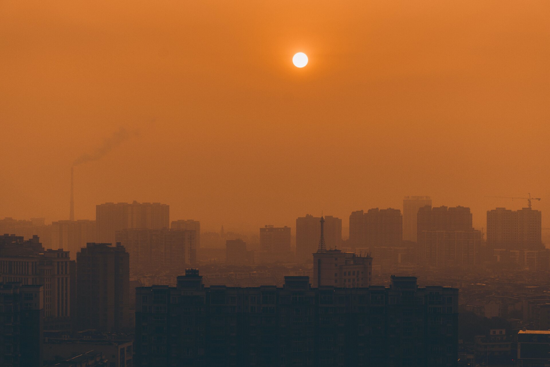 Rys. a. Zdjęcie przedstawia panoramę miasta o zachodzie słońca. Na pierwszym planie zarys budynków jest nieco ciemniejszy niż kolejny plan i zarys budynków widoczny jaśniejszy, jakby we mgle – rozmyty. Niebo jest pomarańczowe, nie tylko z uwagi na porę dnia, ale również smog wydobywający się z kominów. Smog przypomina mgłę, ale są to pyły i opary powstałe w wyniku spalania. Emitowany jest zarówno przez budynki mieszkalne i przemysłowe, ale także przez pojazdy spalinowe. Smog rozchodzi się w powietrzu w wyniku dyfuzji.