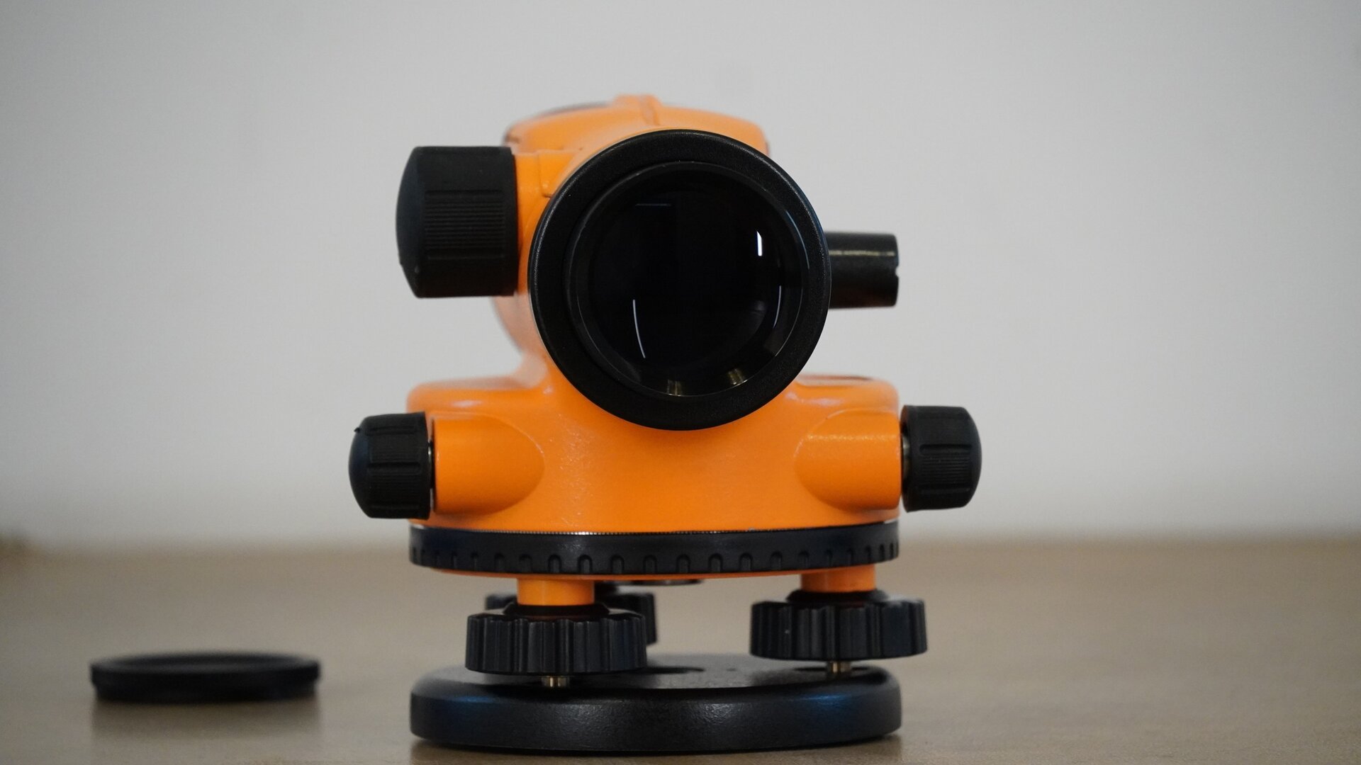 Na zdjęciu przedstawiono niwelator od strony obiektywu. Na lewo od obiektywu widoczne jest pokrętło ustawienia ostrości, na prawo zaś libella, a poniżej korpus z dwoma pokrętłami po bokach oraz kołem poziomym poniżej. Pod kołem poziomym znajdują się trzy śruby umieszczone na okrągłej podstawie, czyli spodarce.