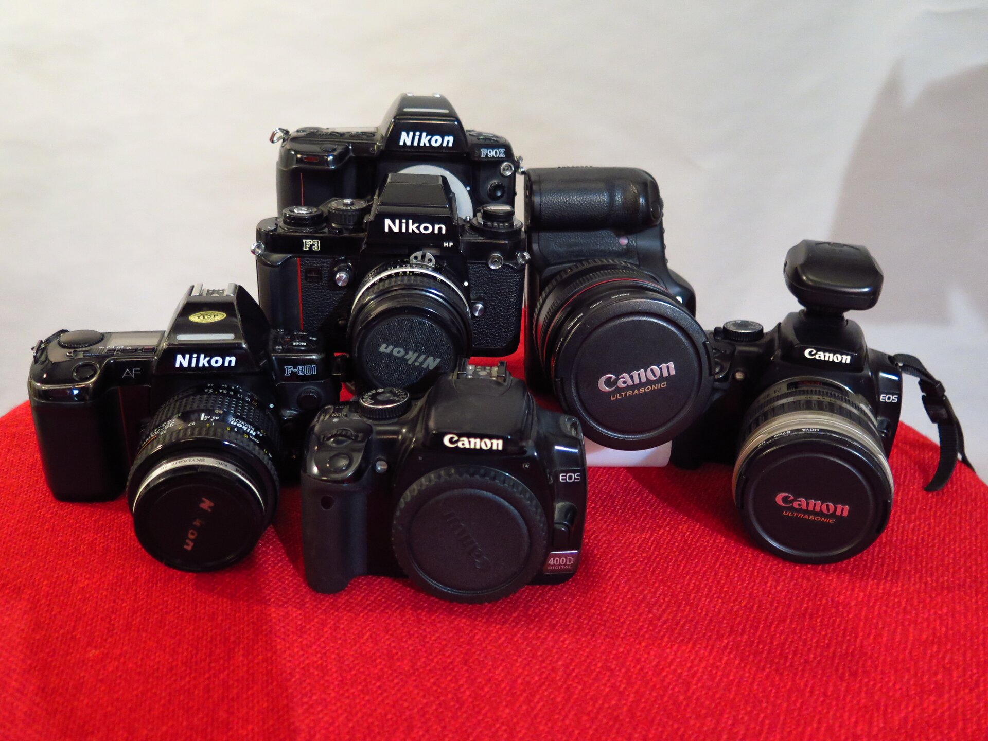 Zdjęcie przedstawia cyfrowe aparaty fotograficzne ustawione obok sobie, wszystkie zwrócone przodem.