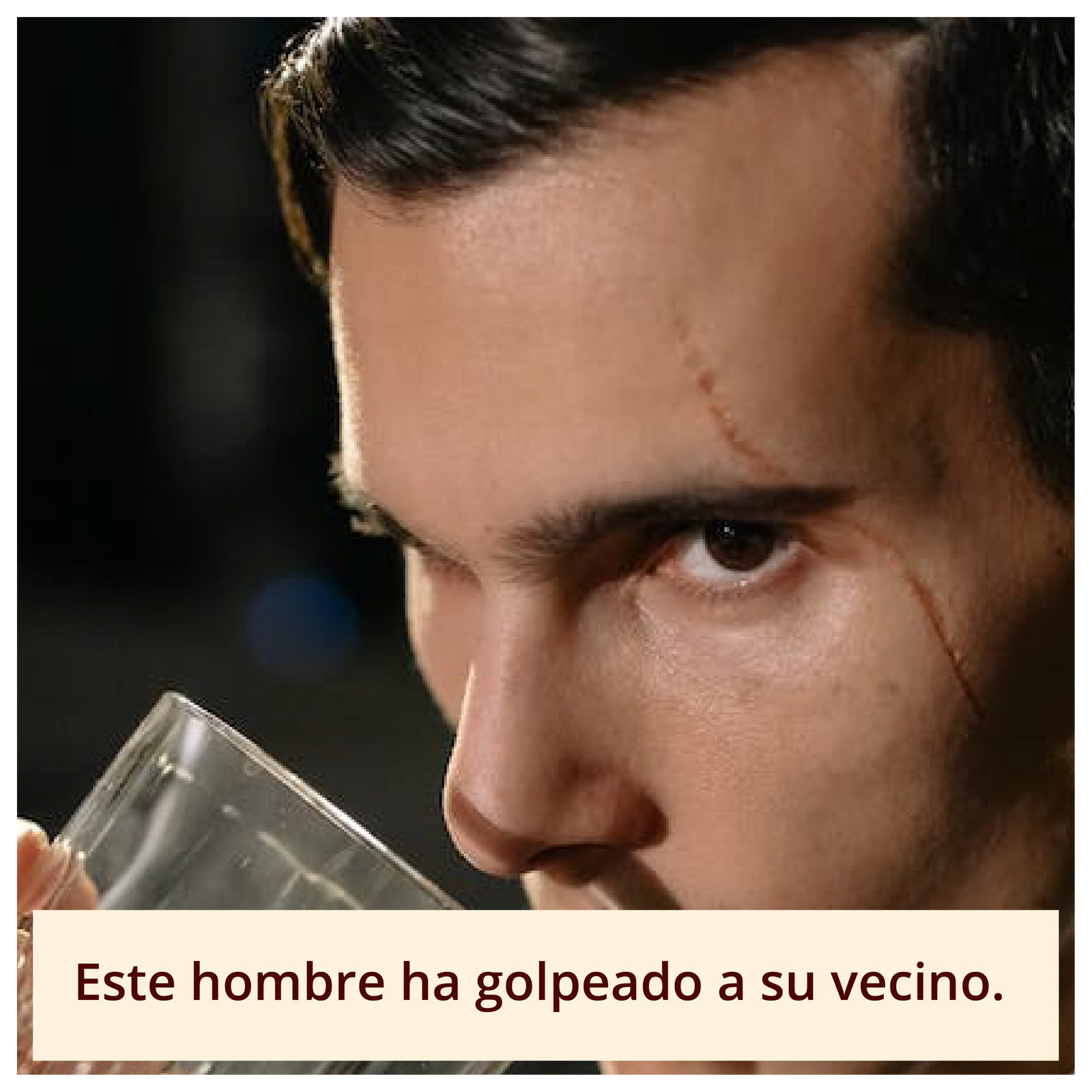 Grafika przedstawia zdjęcie młodego mężczyzny unoszącego szklankę w celu napicia się z niej. Mężczyzna ma poważny wyraz twarzy, na której lewym boku widoczna jest blizna sięgająca od połowy czoła, obok zewnętrznego kącika oka, po środek policzka. Pod zdjęciem znajduje się podpis Este hombre ha golpeado a su vecino.