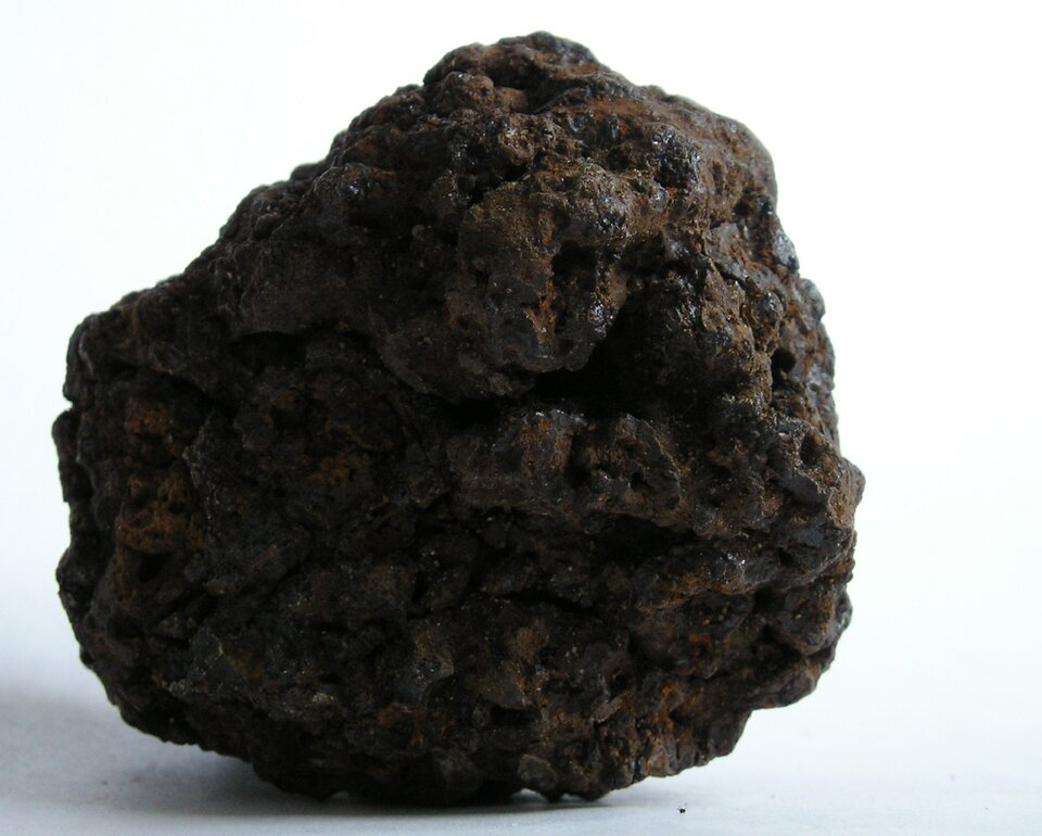 Na zdjęciu przedstawiono kawałek torfu. Skała o barwie brązowej, matowa. Kształtem przypomina zlepioną kulę z błota. 