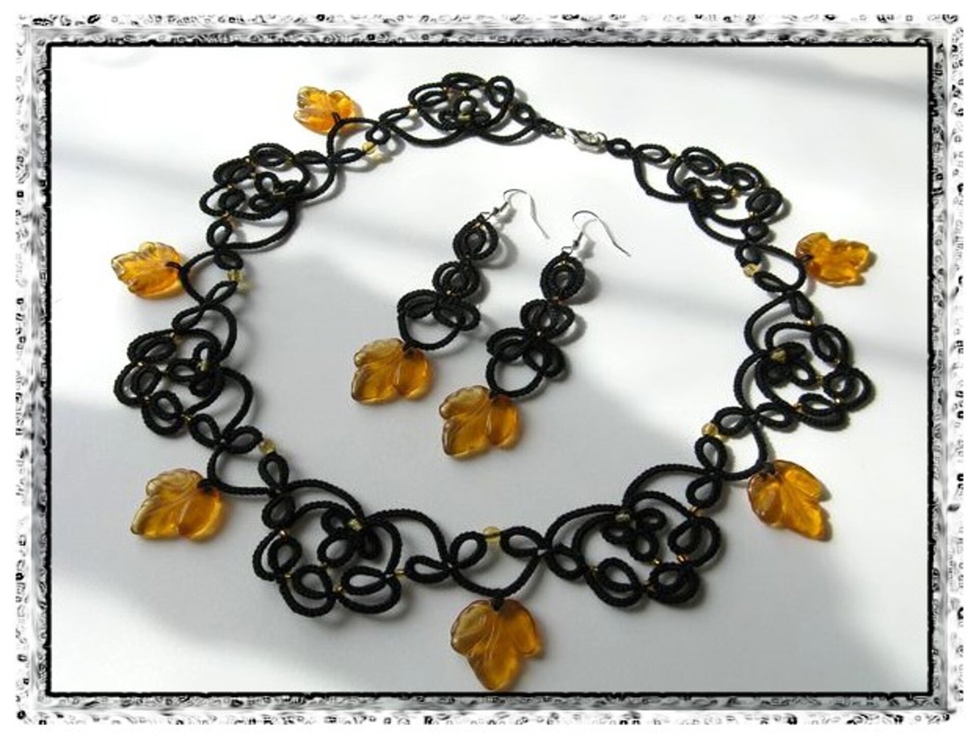 Fotografia przedstawia wyrób rękodzielniczy – naszyjnik i kolczyki. Zestaw zrobiono z połączenia czarnej koronki frywolitkowej i żółtawych koralików w kształcie liści.