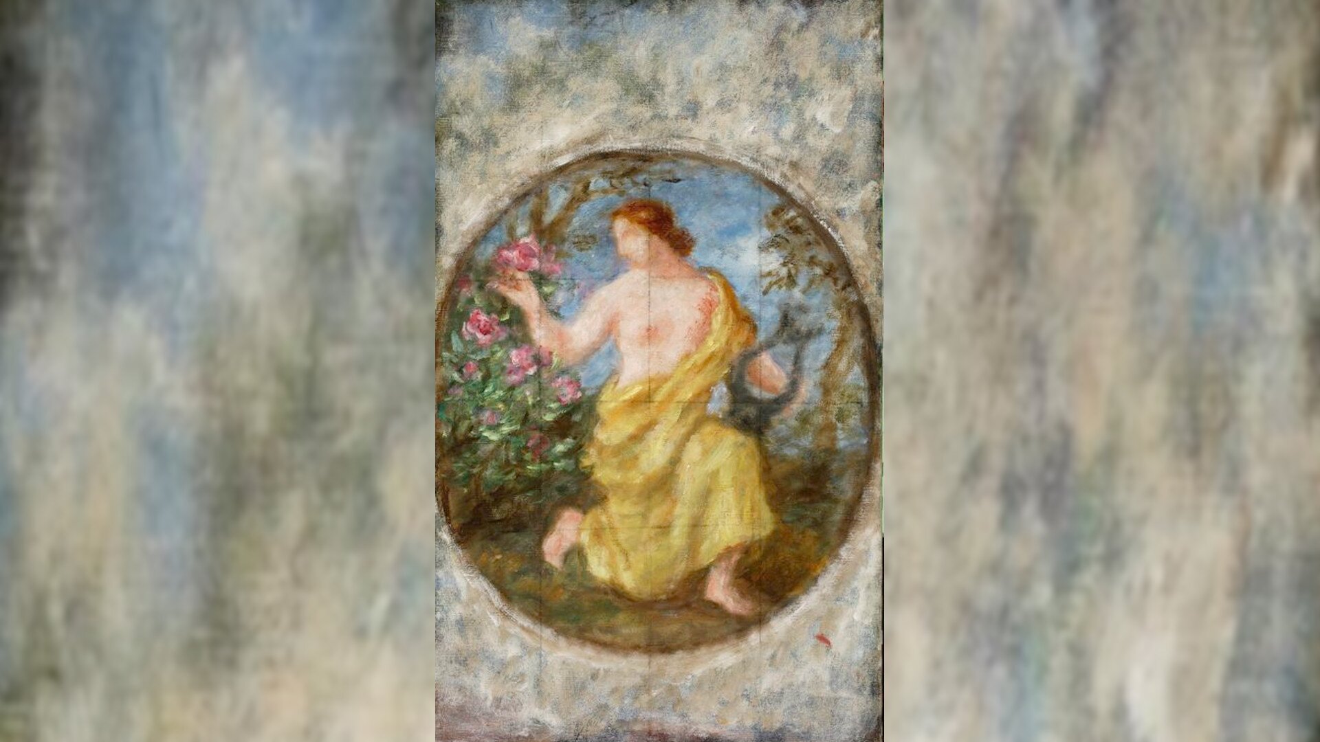 Obraz przedstawia niewyraźną postać półnagiej kobiety przepasanej żółtą szatą. Kobieta jest w ogrodzie i klęcząc na jednym kolanie przypatruje się rosnącym różom.