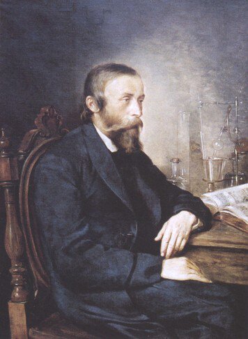 Ilustracja przedstawia obraz na którym uwieczniony jest Ignacy Łukasiewicz od pasa w górę jako starszy mężczyzna siedzący przy biurku na którym znajduje się w tle sprzęt laboratoryjny.