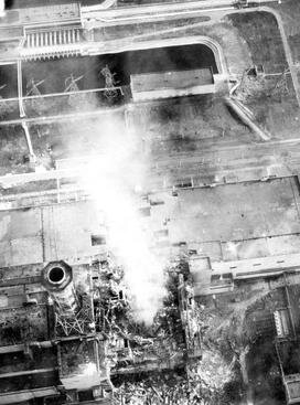 Zdjęcie przedstawia elektrownię jądrową w widoku z lotu ptaka. Z reaktora wydobywa się chmura pary.
