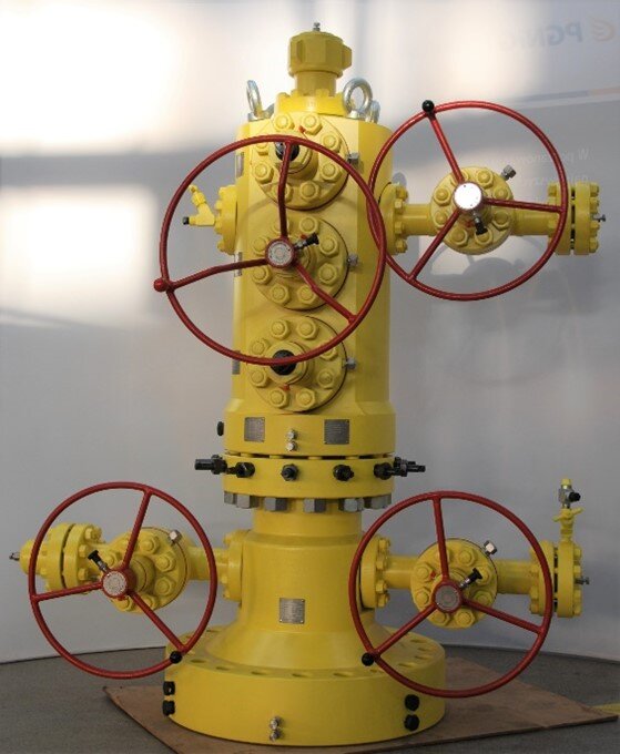 Na zdjęciu widoczna jest głowica eksploatacyjna standardowa, tzw. solid block do eksploatacji jednego horyzontu. Głowica eksploatacyjna to urządzenie montowane na szczycie odwiertu, w celu zamknięcia wylotu odwiertu wiertniczego. Składa się z zaworów i otworów spustowych służących do kontrolowania odwiertu. Głowica widoczna na zdjęciu składa się z głównego trzonu. W jej dolnej części z prawej i lewej strony znajdują się przyłącza na przewody wiertnicze. Przy obu przewodach znajdują się zawory z okrągłymi uchwytami. W centralnej części górnego elementu znajduje się kolejny zawór z okrągłym uchwytem. Z prawej strony górnego elementu znajduje się przewód z zaworem z okrągłym uchwytem. U samej góry znajdują się okrągłe uchwyty do przenoszenia głowicy za pomocą dźwigu.