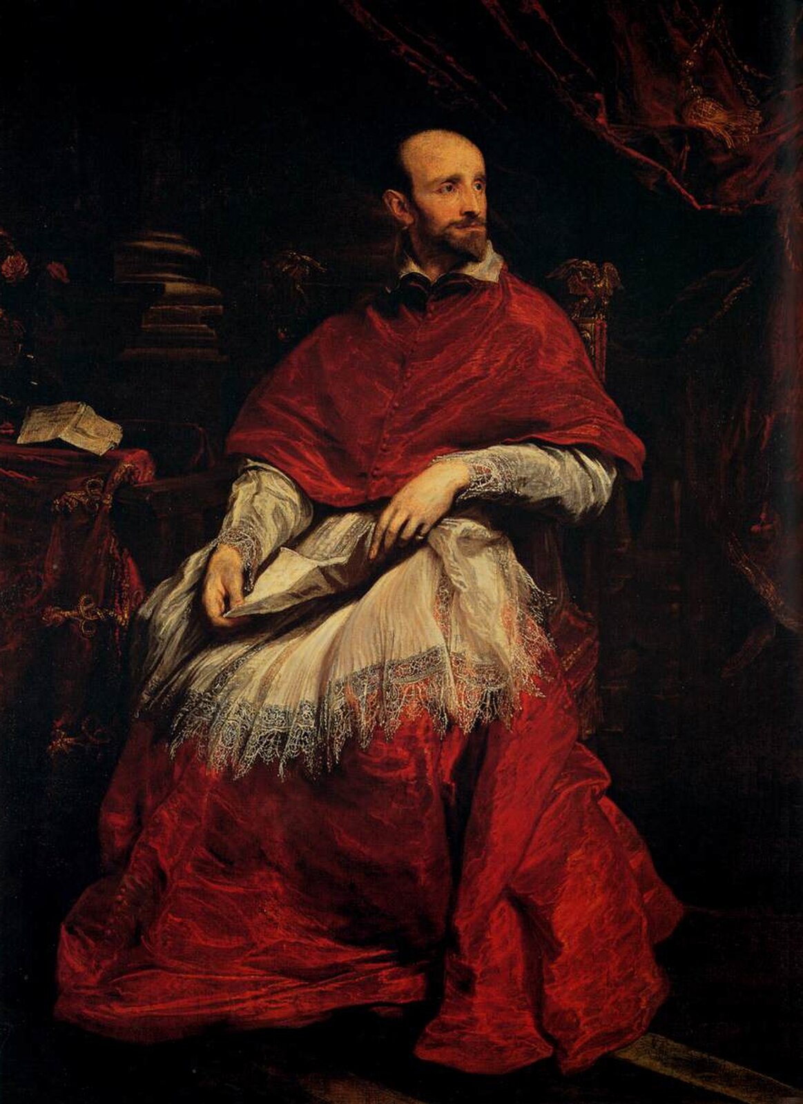 Ilustracja przedstawia obraz Antoona van Dycka „Portret kardynała Bentivoglio”. Na obrazie znajduje się mężczyzna w średnim wieku. Postać siedzi na fotelu, ma smutny wyraz twarzy. Ubrany jest w czerwoną suknię z białą koronką. Na kolanach trzyma kartkę. Spogląda w prawą stronę. Za mężczyzną znajduje się stos książek oraz ciemne tło.