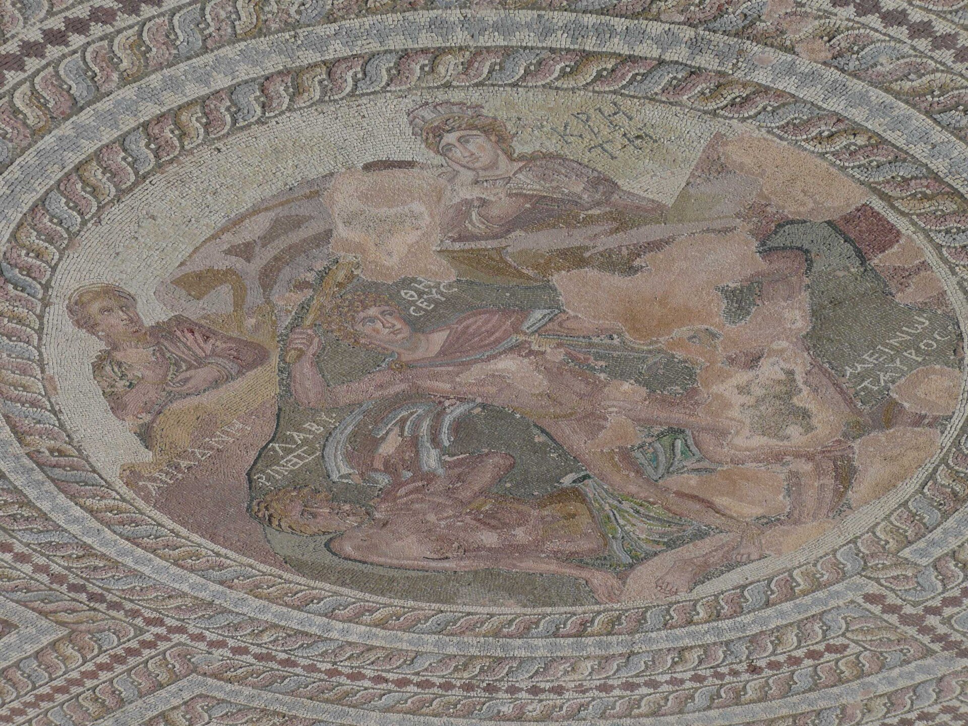 Ilustracja przedstawia mozaikę „Walka Tezeusza z Minotaurem” znajdującą się w Muzeum Archeologicznym w Neapolu. Mozaika ukazuje cztery postacie. Wśród nich w centrum kompozycji znajduje się Tezeusz unoszący jedną z rąk do góry z zamiarem zadania ciosu Minotaurowi.