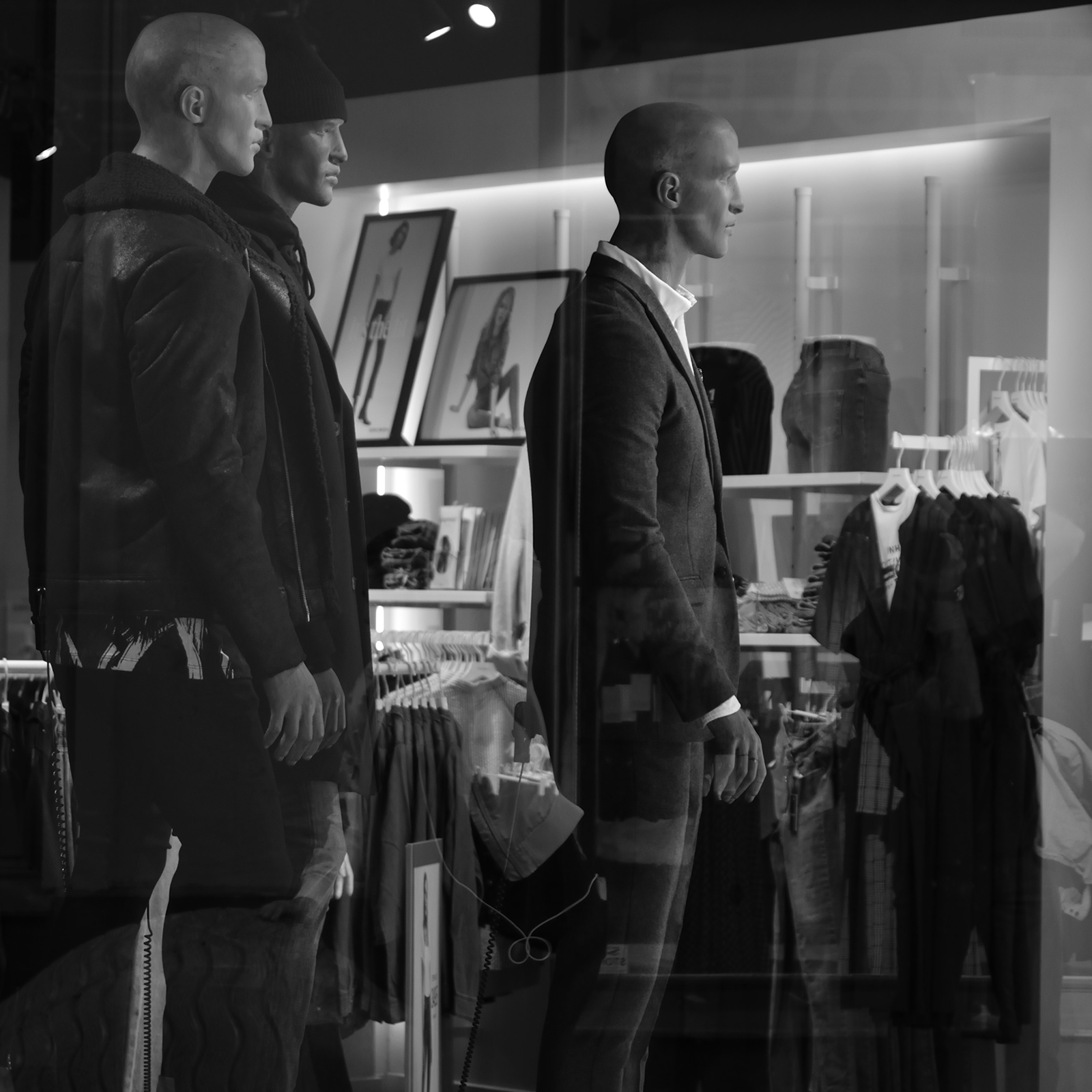 Zdjęcie przedstawia trzy męskie manekiny stojące na wystawie. 